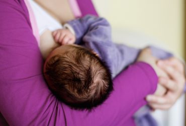 Ouders NVLborstvoeding paars baby gevoed in madonnahouding